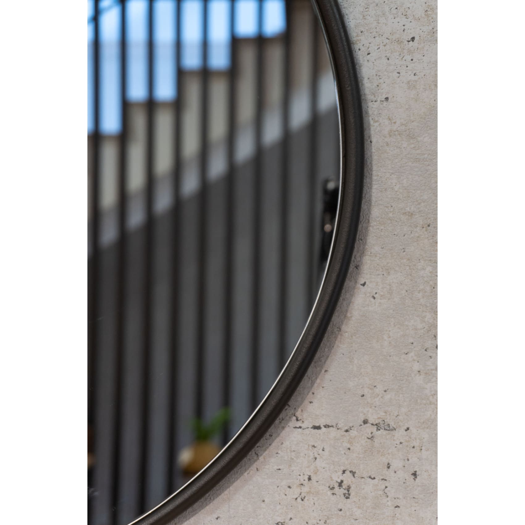 Elegant round Brussels mirror with a unique teardrop design, featuring a steel frame and natural leather strap.