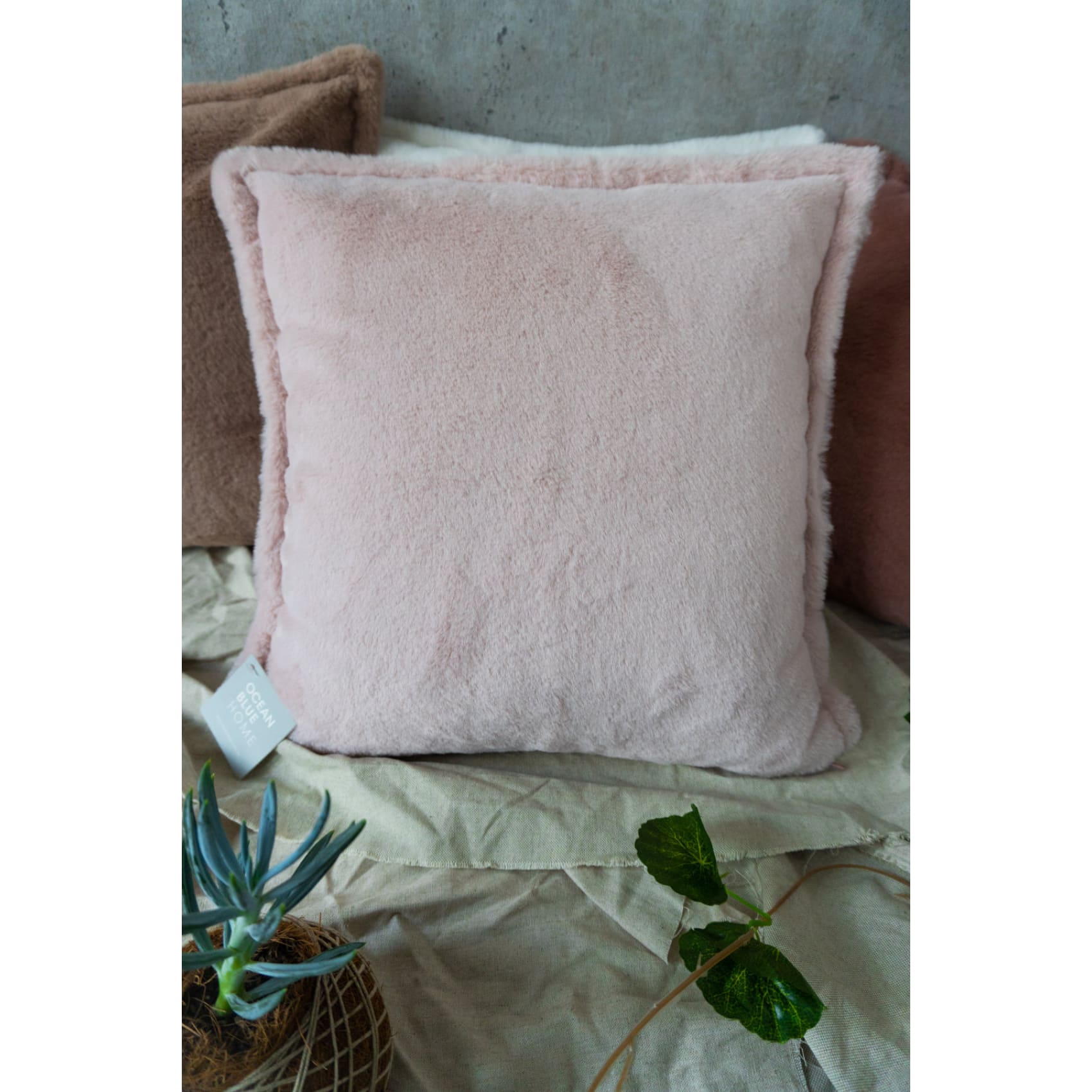 Soft pink Bruselas cushion cover in luxurious fur-like polyester, adding warmth and style to any sofa or bed.